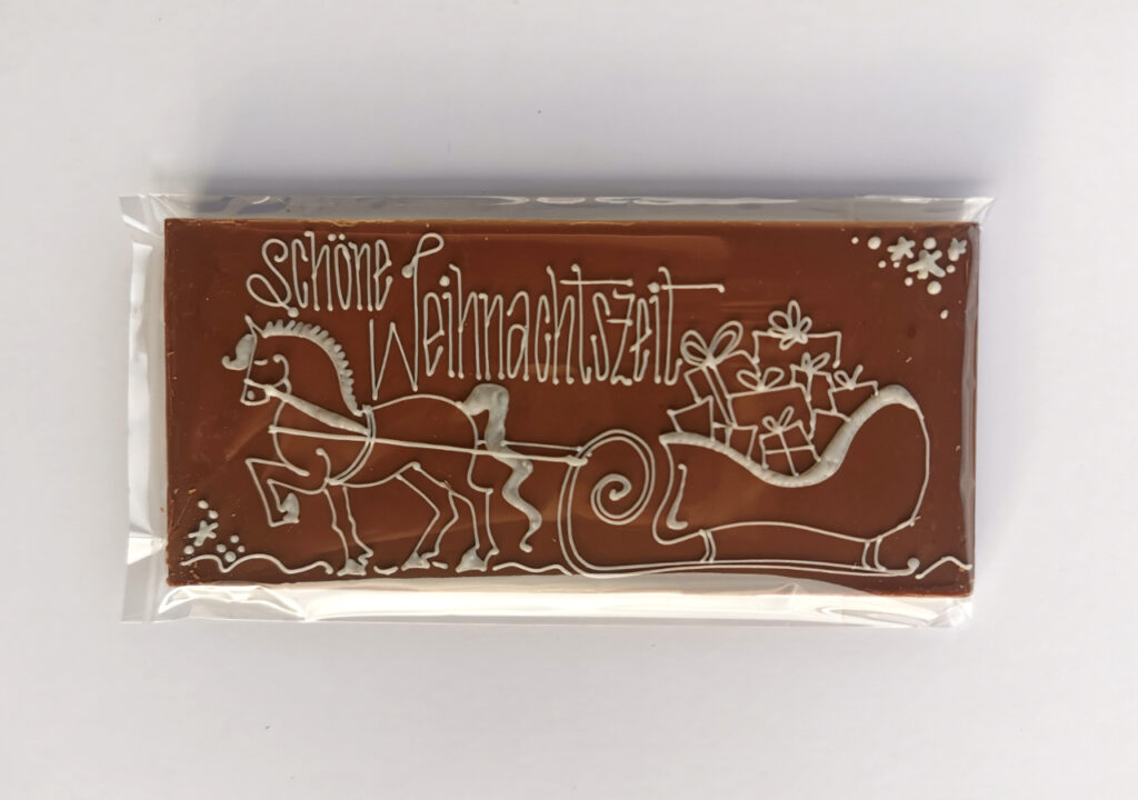 Illustrated chocolate bar, decorated with white chocolate. A gift for christmas